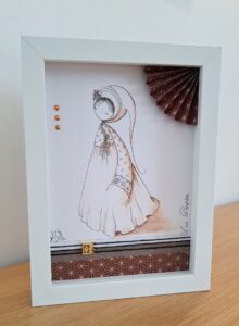 tableau encre et papier dans un cadre vitrine petit format représentant un personnage appelé Poupir Kokeshi dans sa tenue traditionnelle japonaise.