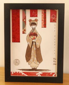 tableau encre et papier dans un cadre vitrine petit format représentant un personnage appelé Poupir Kokeshi dans sa tenue traditionnelle japonaise.