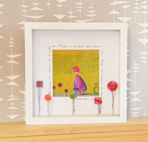 tableau vitrine décorative à partir d’une reproduction de son petit personnage appelé Poupir et décoré d’éléments de customisation composé de rubans perles origami