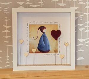tableau vitrine décorative à partir d’une reproduction de son petit personnage appelé Poupir et décoré d’éléments de customisation composé de rubans perles origami
